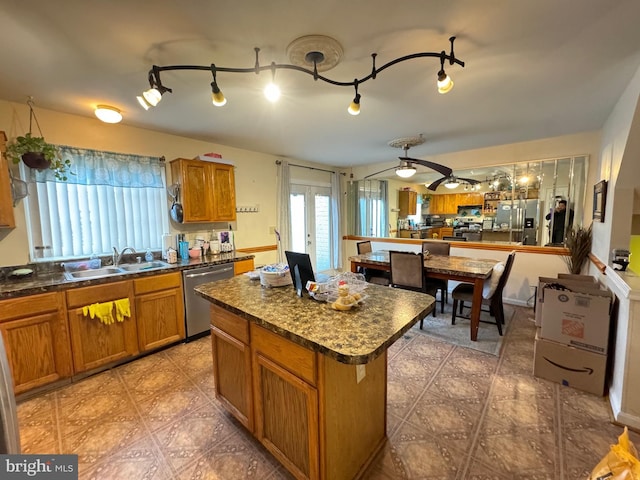 kitchen with french doors, stainless steel appliances, ceiling fan, sink, and a center island