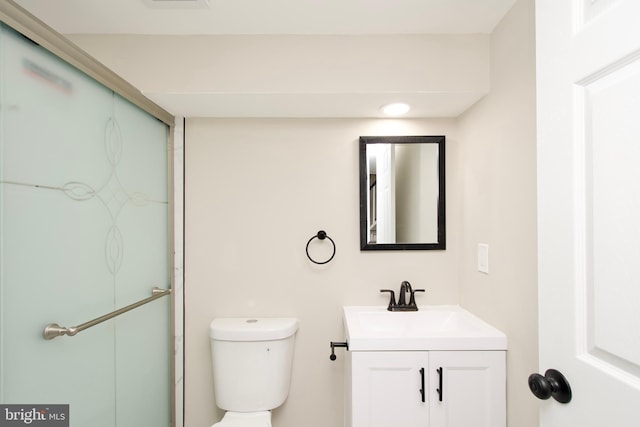 bathroom with an enclosed shower, vanity, and toilet