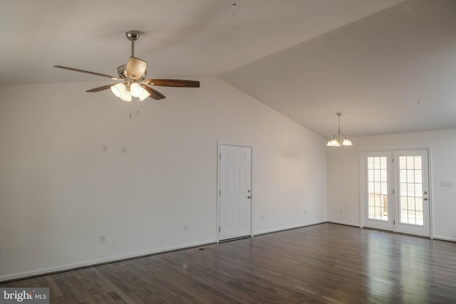 spare room with ceiling fan with notable chandelier, dark hardwood / wood-style flooring, and vaulted ceiling