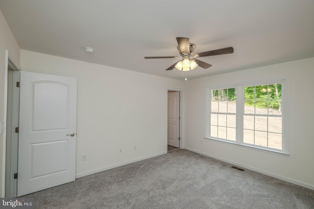 spare room featuring light carpet and ceiling fan