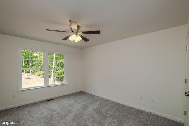 carpeted spare room featuring ceiling fan