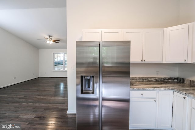 kitchen with white cabinets, dark hardwood / wood-style floors, stainless steel fridge, dark stone countertops, and ceiling fan