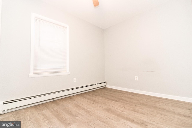 empty room with baseboard heating and light hardwood / wood-style flooring