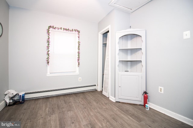 unfurnished bedroom with a baseboard radiator and hardwood / wood-style flooring