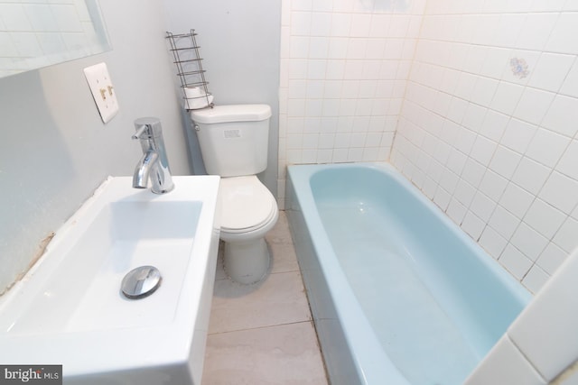 bathroom featuring tile patterned flooring, toilet, and a bath