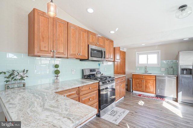 kitchen featuring decorative backsplash, sink, light hardwood / wood-style flooring, and appliances with stainless steel finishes