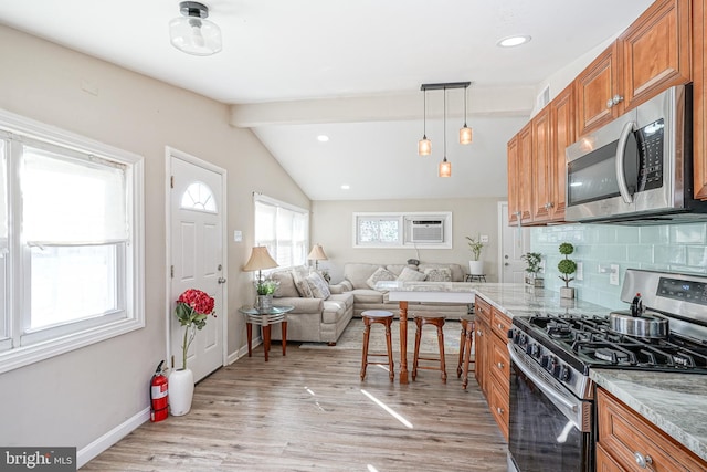 kitchen with decorative backsplash, appliances with stainless steel finishes, pendant lighting, light hardwood / wood-style flooring, and vaulted ceiling with beams