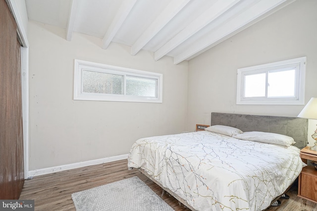 bedroom featuring vaulted ceiling with beams and wood-type flooring