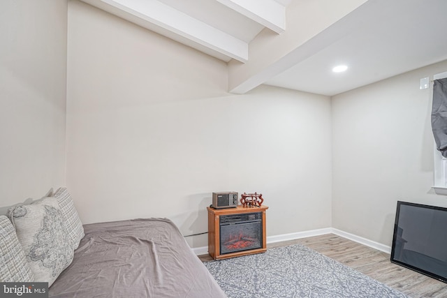 bedroom featuring beam ceiling and hardwood / wood-style flooring