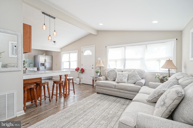 living room featuring vaulted ceiling with beams and light wood-type flooring