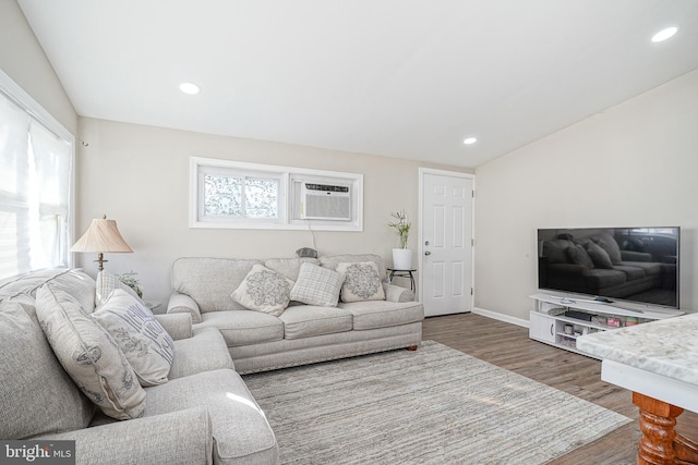 living room with hardwood / wood-style flooring and an AC wall unit