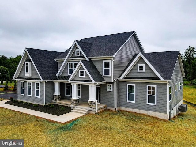 view of front of house with central AC unit and a front lawn