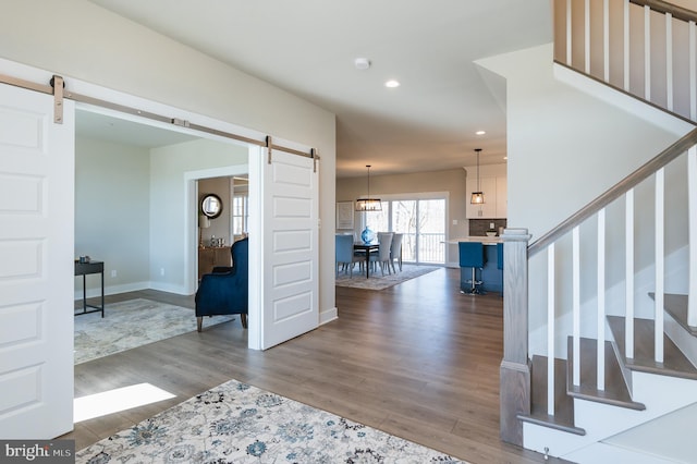 entryway with a barn door and hardwood / wood-style floors