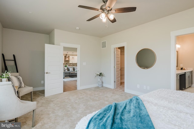 carpeted bedroom with connected bathroom, a walk in closet, and ceiling fan