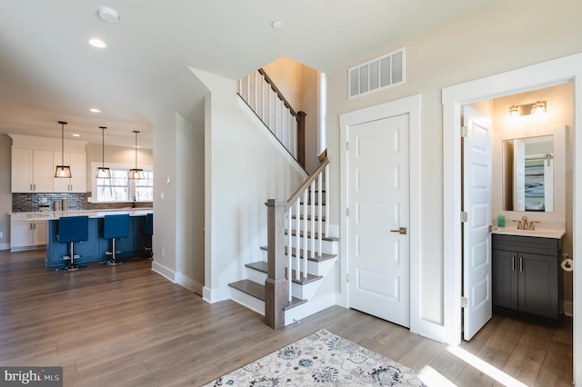 staircase with sink and hardwood / wood-style floors