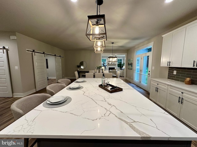 3104 Paper Mill Rd, Phoenix, MD 21131 - kitchen with a barn door, a spacious island, dark wood-style flooring, and decorative light fixtures