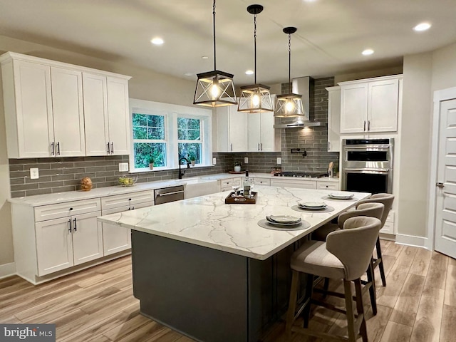 3104 Paper Mill Rd, Phoenix, MD 21131 - kitchen with wall chimney exhaust hood, stainless steel appliances, light wood finished floors, white cabinetry, and recessed lighting