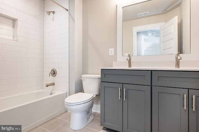 full bathroom featuring tile patterned flooring, tiled shower / bath, vanity, and toilet