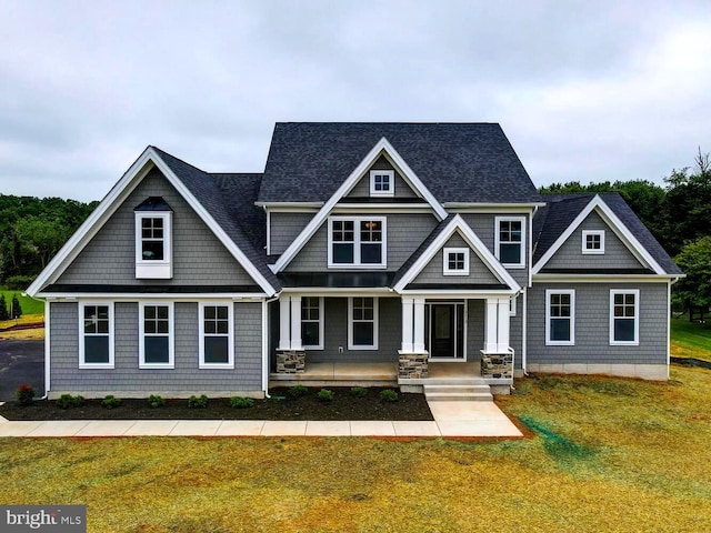 craftsman inspired home featuring covered porch and a front yard