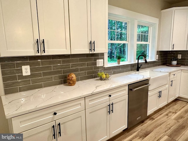 3104 Paper Mill Rd, Phoenix, MD 21131 - kitchen with stainless steel dishwasher, a sink, light wood finished floors, white cabinetry, and light stone counters
