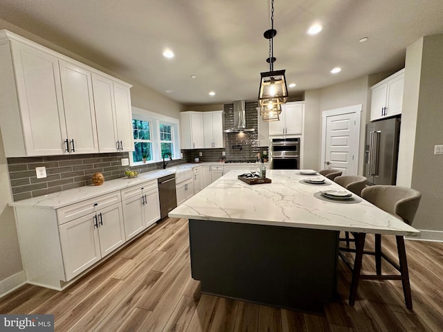3104 Paper Mill Rd, Phoenix, MD 21131 - kitchen featuring wall chimney range hood, stainless steel appliances, a breakfast bar area, a kitchen island, and wood finished floors