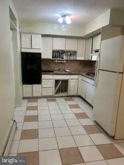 kitchen with white cabinets, white fridge, oven, and light tile patterned flooring