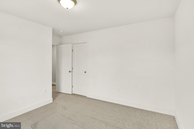 spare room featuring light colored carpet