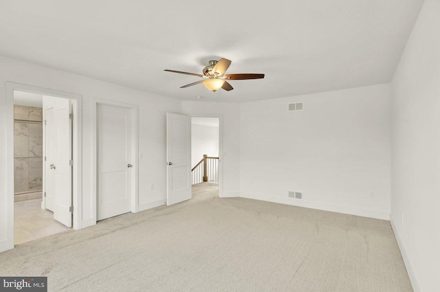 unfurnished bedroom with ensuite bathroom, ceiling fan, and light colored carpet