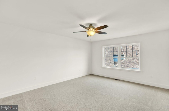 carpeted spare room with ceiling fan