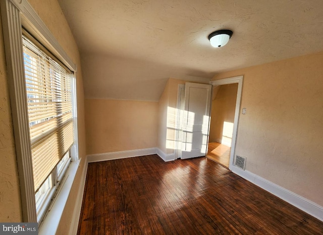 additional living space with dark hardwood / wood-style floors and lofted ceiling