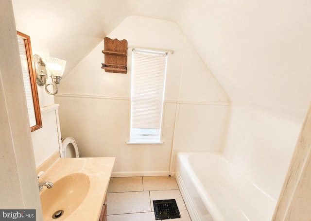 bathroom with tile patterned flooring, vanity, a bath, and vaulted ceiling