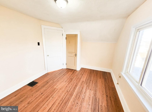 bonus room with light hardwood / wood-style floors and vaulted ceiling