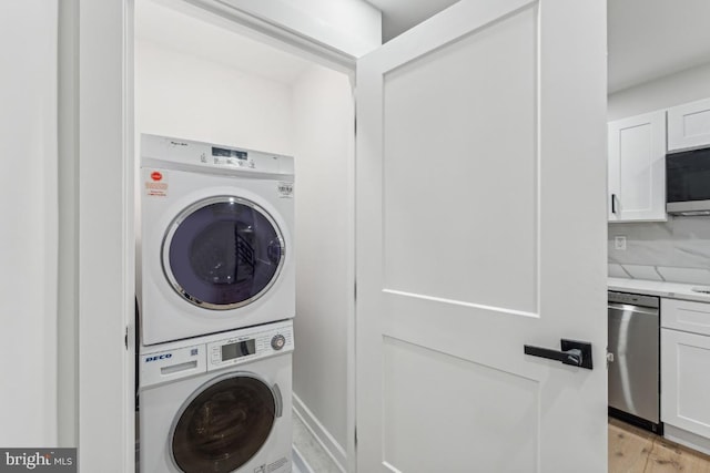 laundry room with stacked washer / dryer and light hardwood / wood-style flooring