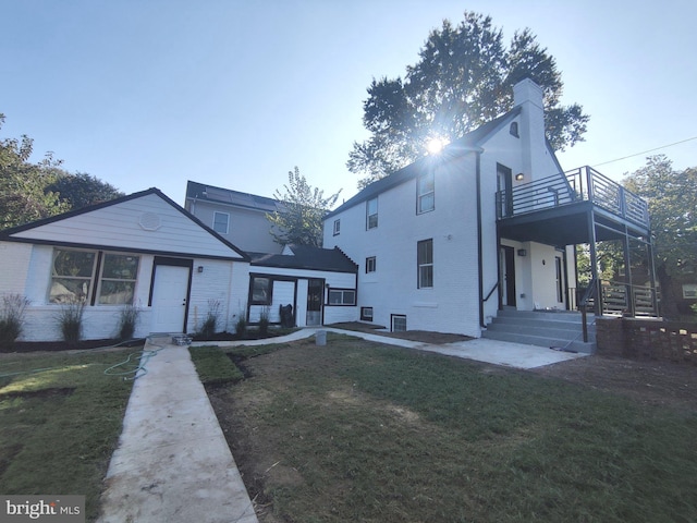 view of front of property featuring a balcony and a front yard