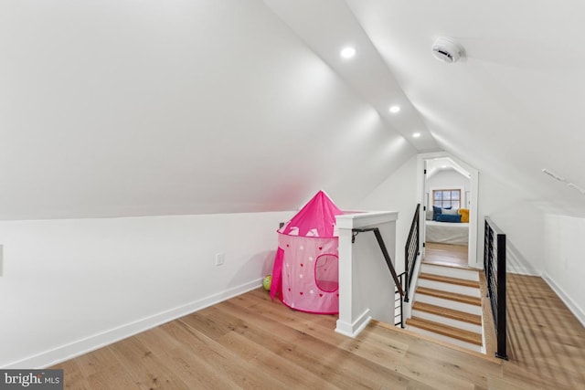 playroom featuring hardwood / wood-style floors and lofted ceiling