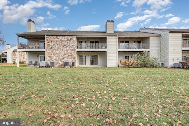 back of property with a lawn and cooling unit