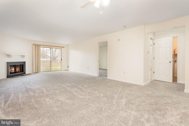 unfurnished living room with light carpet and ceiling fan