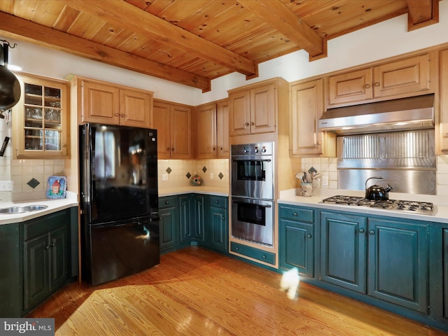 kitchen featuring appliances with stainless steel finishes, sink, wooden ceiling, and decorative backsplash