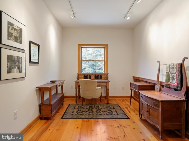 office space with rail lighting and light hardwood / wood-style floors