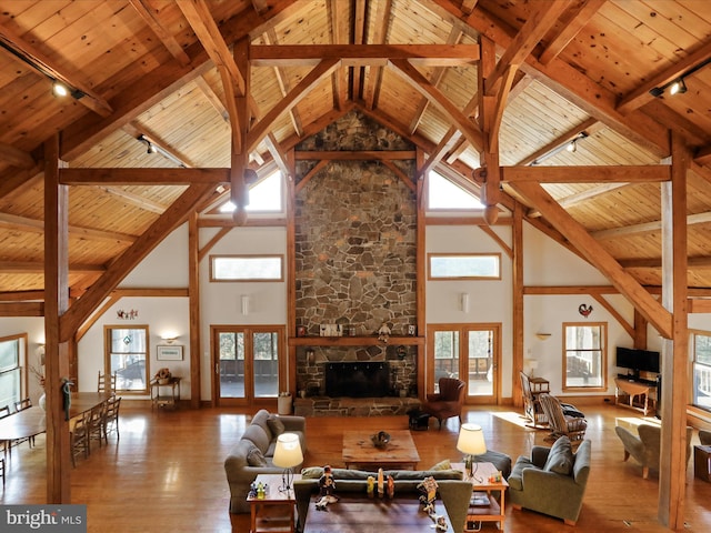 living room featuring wood ceiling, wood-type flooring, a fireplace, and french doors