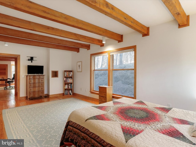 bedroom with beamed ceiling and light wood-type flooring