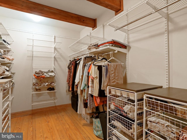 spacious closet featuring wood-type flooring and beamed ceiling