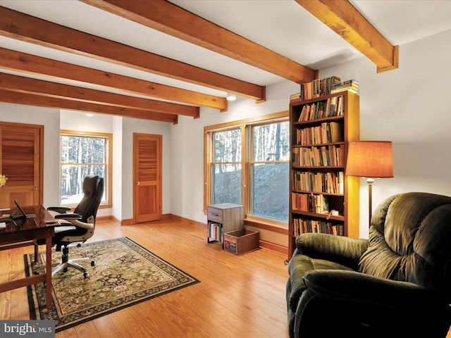 office with beam ceiling and light wood-type flooring