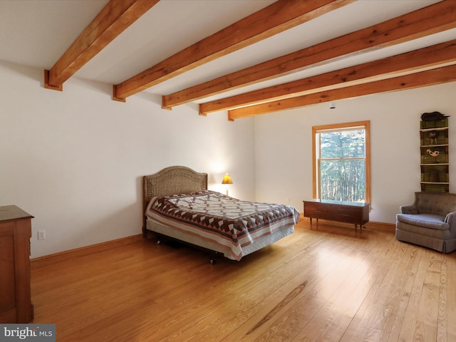 bedroom featuring beamed ceiling and light hardwood / wood-style floors