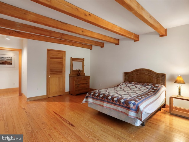 bedroom with beam ceiling and wood-type flooring