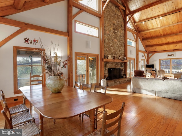 dining room with wood ceiling, hardwood / wood-style flooring, a fireplace, and a wealth of natural light