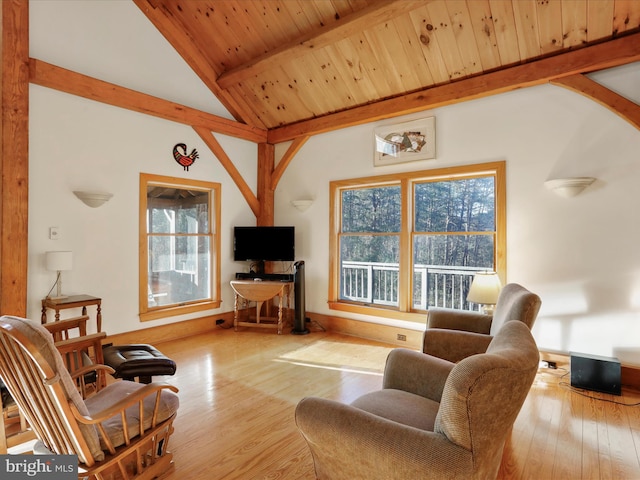 living room with vaulted ceiling with beams, light hardwood / wood-style floors, and wooden ceiling