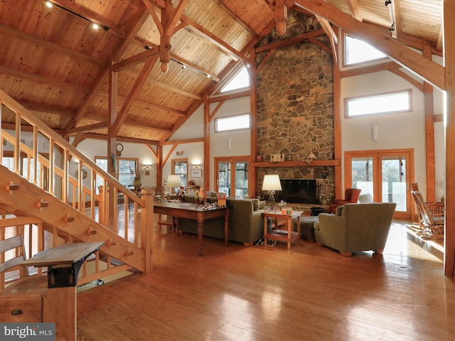 living room with a stone fireplace, wooden ceiling, and hardwood / wood-style flooring