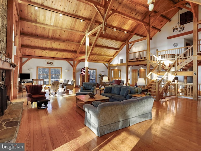 living room featuring high vaulted ceiling, beam ceiling, light hardwood / wood-style flooring, and wooden ceiling