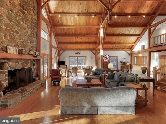 living room featuring high vaulted ceiling, hardwood / wood-style flooring, a fireplace, and wooden ceiling